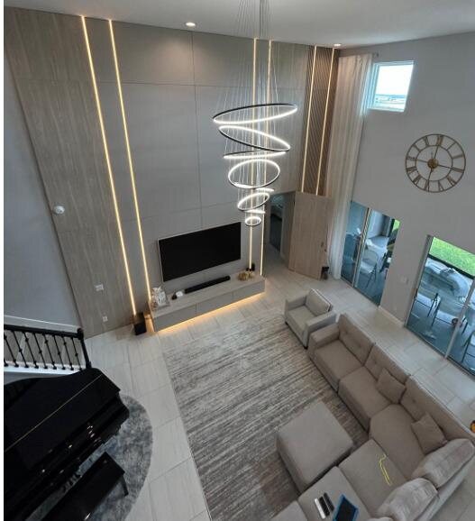 Double-height luxury living room with architectural feature wall by LEGNO