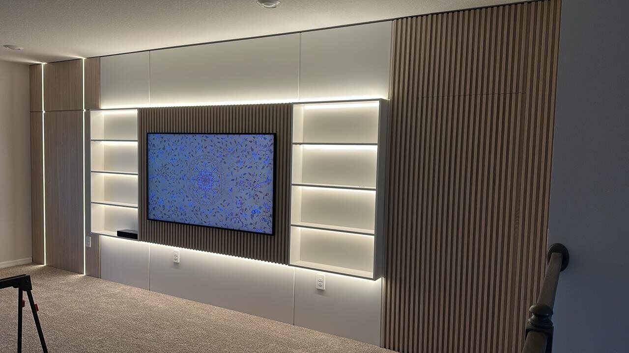 Contemporary custom media wall with slatted wood and integrated lighting