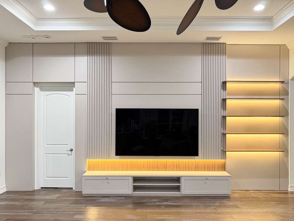 White frameless media wall with illuminated shelving